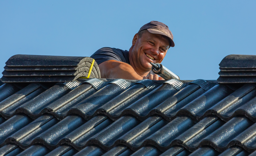 male roofer smiling while working